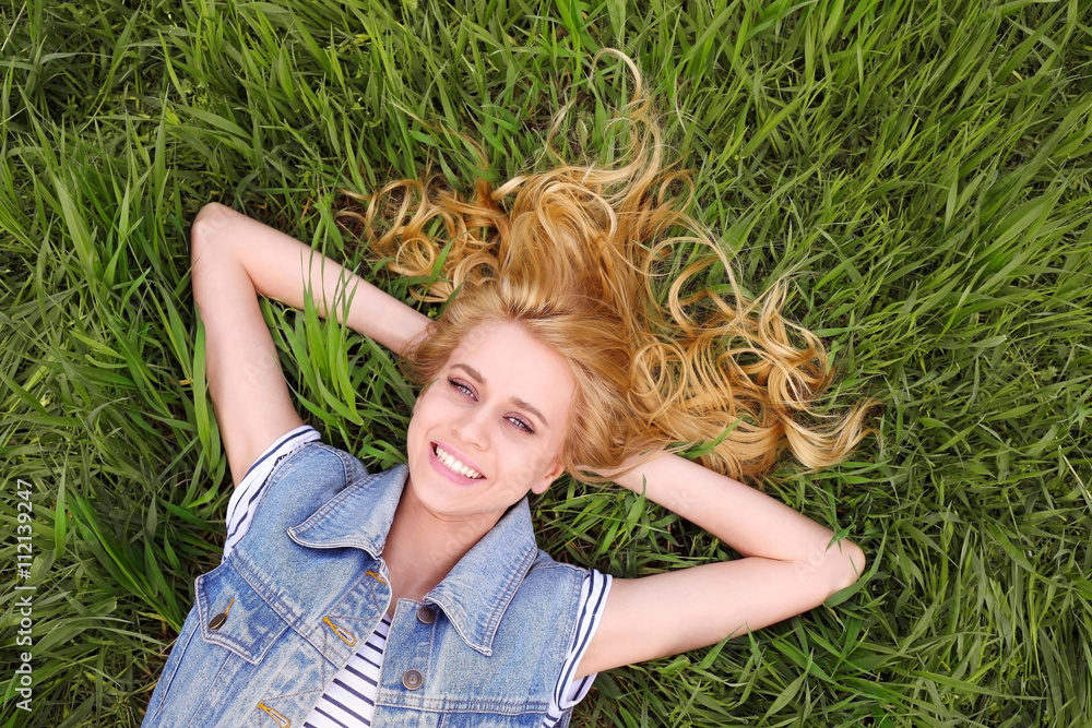 Young beautiful woman on green grass