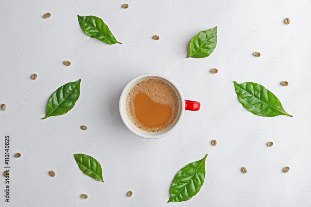 Cup of tasty coffee with leaves on white background