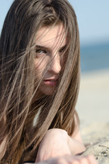 Lying on sand and the wind blowing her hair