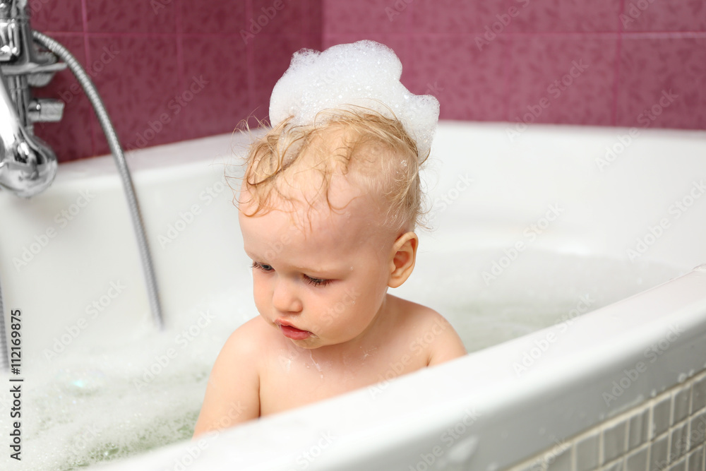 Cute baby boy with foam in bath