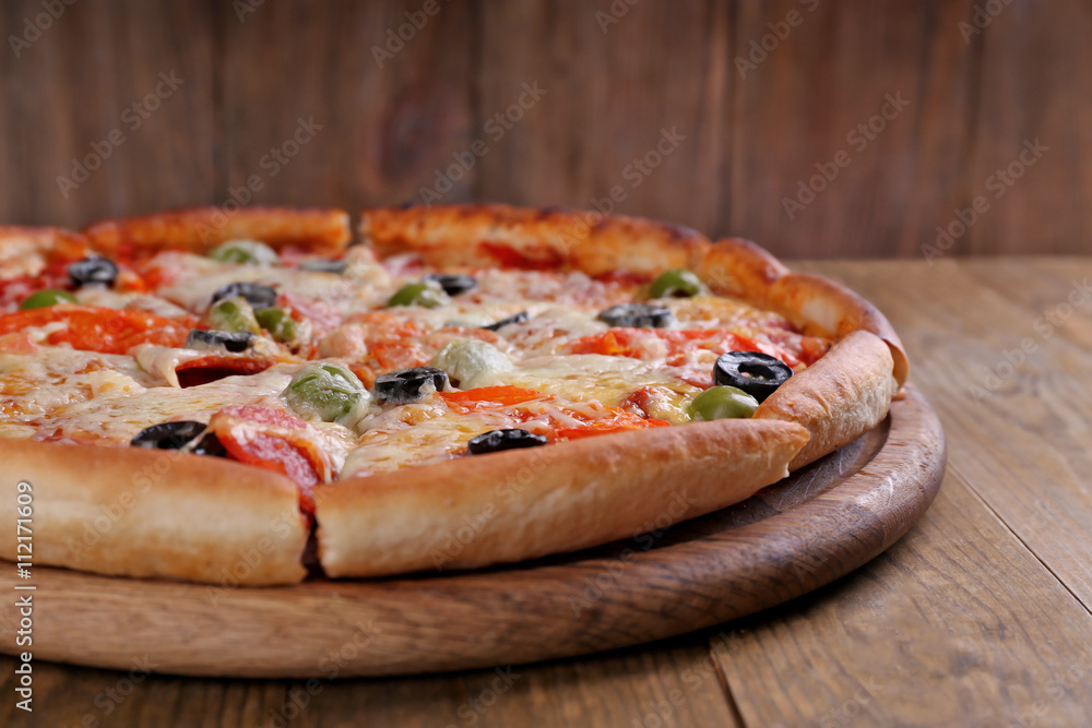 Pizza with cheese on board and wooden table background