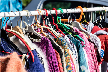 Wall Mural - used female sweaters on rack for reusing at flea market