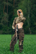 Attractive hunter girl with hunting carbine looking out the trop
