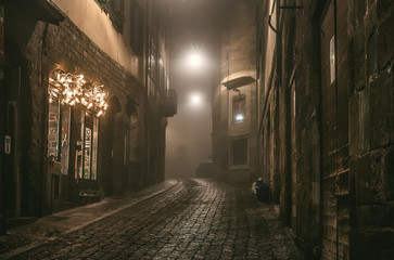 old european narrow empty street of medieval town on a foggy evening. taken in bergamo, citta alta, 