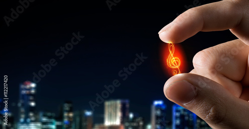 Zdjęcie XXL Notatka muzyczna między palcami