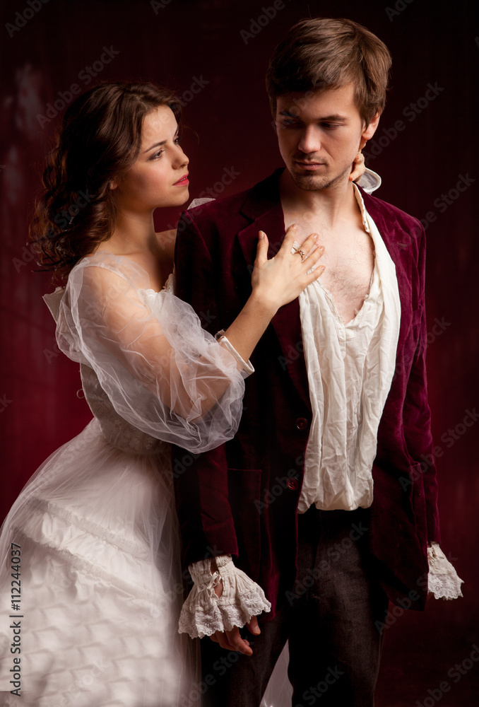 Beautiful man and woman dressed in medieval clothing stand in a room of ...