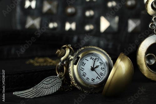 Photographie women's bag with old clocks as a pendant on a black background