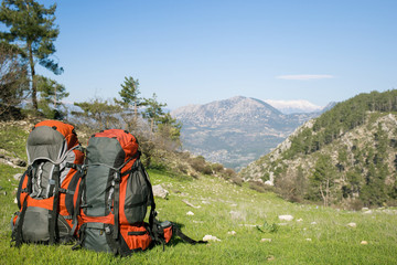 Camping with backpacks in the mountains on a sunny summer day.