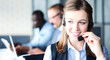 © ty - Portrait of call center worker accompanied by her team. Smiling customer support operator at work.