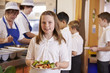 © Monkey Business - Schoolgirl holding a plate of food in a school cafeteria