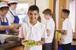© Monkey Business - Hispanic schoolboy holds a plate of food in school cafeteria