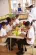 © Monkey Business - Primary school kids eat lunch in school cafeteria, vertical