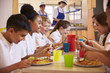 © Monkey Business - Primary school kids at a table in school cafeteria, close up