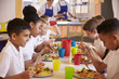 © Monkey Business - Primary school kids eating at a table in school cafeteria