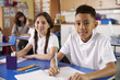 © Monkey Business - Two primary school pupils in classroom looking to camera