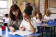 © Monkey Business - Primary school teacher helping a schoolgirl at her desk