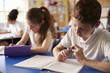 © Monkey Business - Two kids working at their desks in primary school, close up