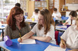 © Monkey Business - Primary school teacher helping a girl writing at her desk