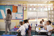 © Monkey Business - Primary school teacher writing on a flip chart in a lesson