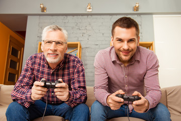 Poster - Happy man and his father playing video games while sitting on so