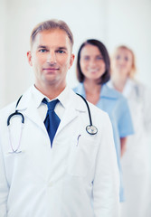 Wall Mural - doctor with stethoscope and colleagues