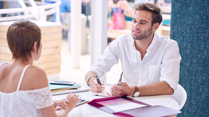 Wall Mural - Male tutor mentoring female student in co-work space