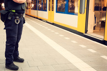 Police Officer Guarding A Train Station To Prevent Terrorist Attacks.