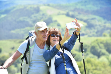 senior couple taking selfie picture on iking day