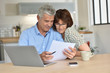© goodluz - Senior couple using laptop computer at home