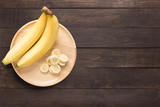 Fototapeta Góry - Bananas in a wooden dish on a wooden background. space for text