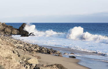 Wall Mural - Beach landscape in Malibu. The ocean and waves during strong winds in United States, California. Waves breaking on the rocks.
