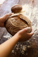 Wall Mural - Brown bread in hands