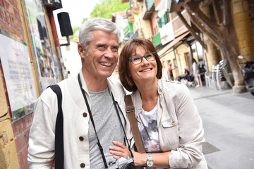 senior couple of tourists visiting spanish little town