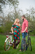 © anatoliy_gleb - Loving young couple with bicycles against the background of trees and fresh greenery in spring garden. Couple together enjoying romantic holidays