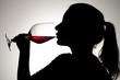 silhouette of a girl sipping on red wine