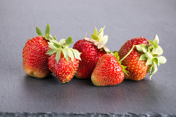 Wall Mural - Heap of ripe red strawberries on slate blackboard