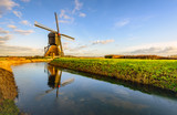 Dutch polder mill reflected by low afternoon sunlight