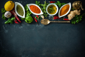 Wall Mural - Herbs and spices over black stone background