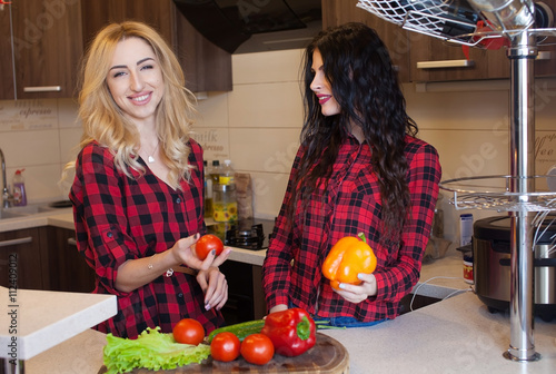 Two Sexy Woman Blond And Brunette In Red Shirt Cooking On Kitchen