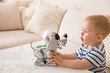© goodmoments - Adorable toddler boy playing with interactive toy. Child with toy robot dog. indoors. Activities for small children. Communication and digital concept.