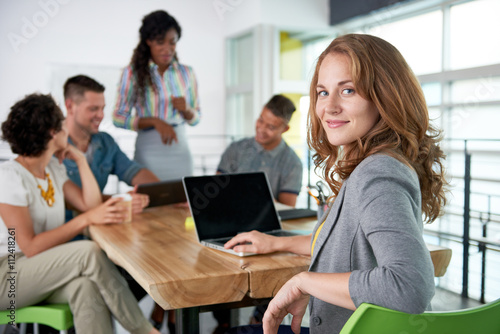 Fotomural Image of a succesful casual business woman using laptop during meeting