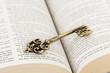 Vintage key on holy bible page concept theology study