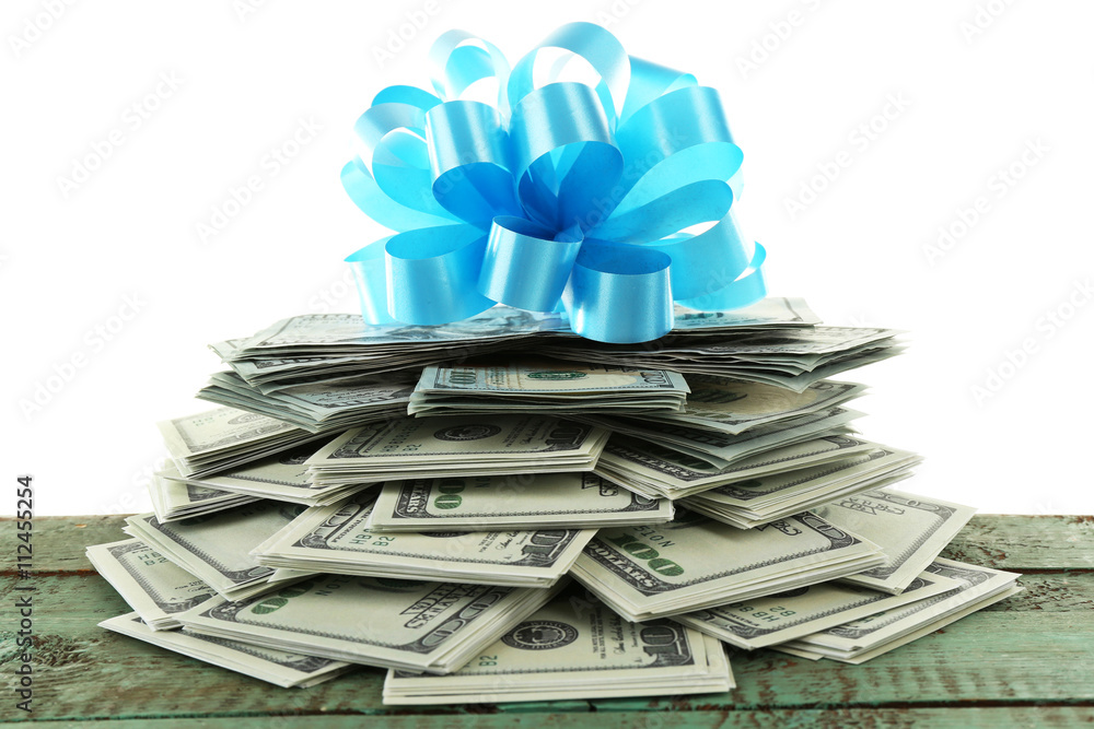 Pile of dollars with bow as gift isolated on white