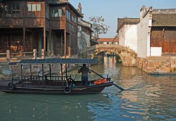 Wall Mural - Shanghai, Wuzhen historic scenic town old houses, bridge and boat for tourists along a canal. 