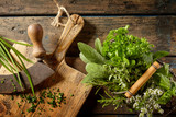 Various herbs in preparation on cutting board