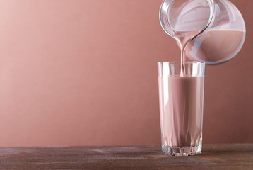 Wall Mural - Milk chocolate is poured into a glass