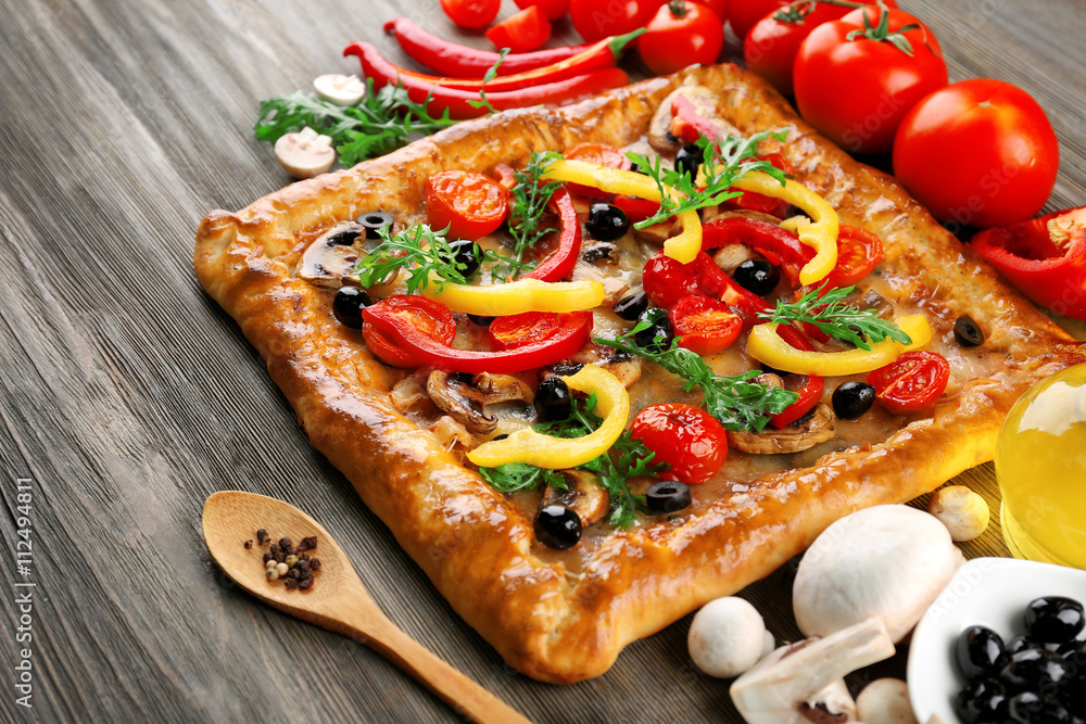 Freshly homemade pizza on wooden background