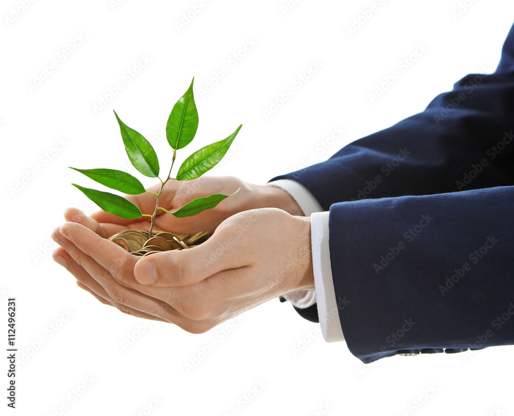 Hands holding plant sprouting from a handful of coins on white background