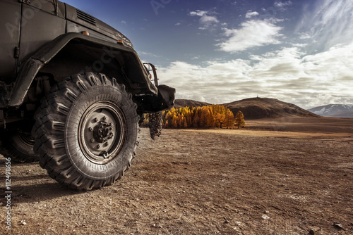 Fotografia  Truck car wheel on offroad steppe adventure trail