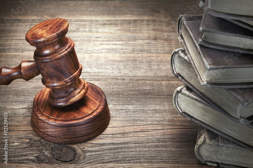 Fototapeta na wymiar Wooden Judges Gavel And Old Law Books On Wooden Table